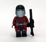 Minifigure with red and black outfit holding a weapon on a white background